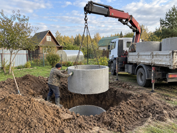 Кольца септика опускают краном-манипулятором